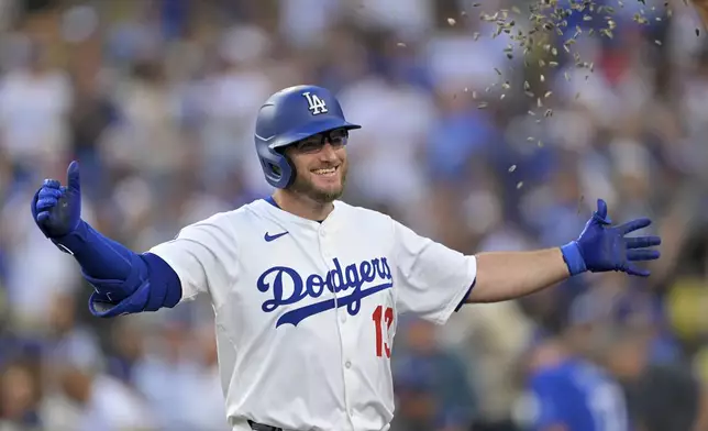 Los Angeles Dodgers' Max Muncy gets showered with seeds at the dugout after a solo home run during the first inning of a baseball game against the St. Louis Cardinals, Tuesday, Aug. 5, 2025, in Los Angeles. (AP Photo/Jayne Kamin-Oncea)