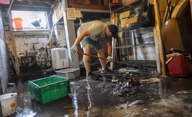 Patrick Carrol helps clean out the basement of Franky's Newport bar, Monday, Aug. 11, 2025, in Milwukee. (AP Photo/Andy Manis)