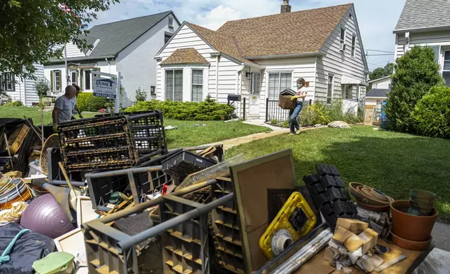 Mandaline Bergstrom works on cleaning out her basement, Aug. 11, 2025, in Milwaukee. (AP Photo/Andy Manis)