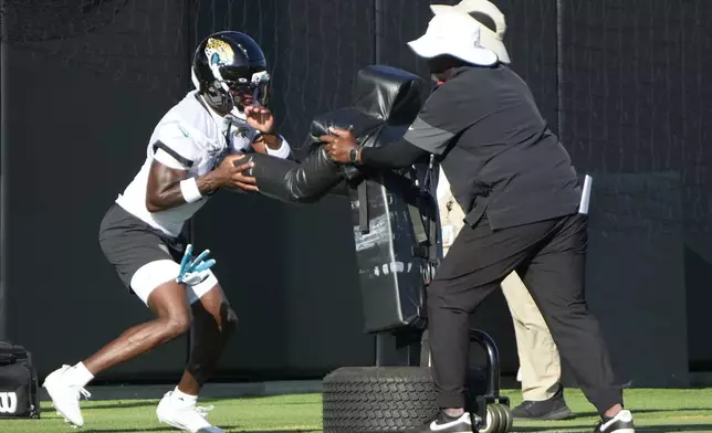Jacksonville Jaguars defensive back Travis Hunter, left, performs a drill during practice at the team's NFL football training camp, Sunday, July 27, 2025, in Jacksonville, Fla. (AP Photo/John Raoux)