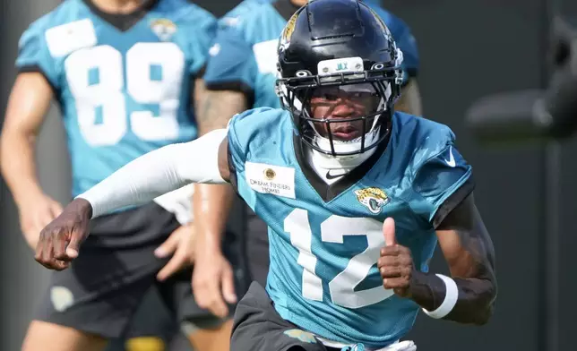 Jacksonville Jaguars wide receiver Travis Hunter (12) runs through a drill during practice at the team's NFL football training camp, Wednesday, July 23, 2025, in Jacksonville, Fla. (AP Photo/John Raoux)