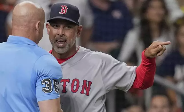 Boston Red Sox manager Alex Cora, right, argues with home plate umpire Ryan Blakney (36) after being ejected during the seventh inning of a baseball game against the Houston Astros Wednesday, Aug. 13, 2025, in Houston. (AP Photo/David J. Phillip)