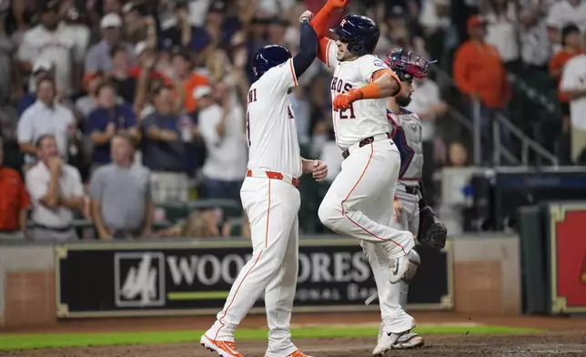 Houston Astros' Yainer Diaz (21) celebrates with Victor Caratini after hitting a two-run home run against the Boston Red Sox during the sixth inning of a baseball game Wednesday, Aug. 13, 2025, in Houston. (AP Photo/David J. Phillip)