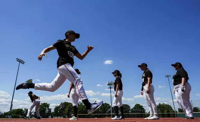 Players wait in line on the field as Emily DeCotiis runs past during the first day of tryouts for the Women's Professional Baseball League, Friday, Aug 22, 2025, at the Washington Nationals Youth Baseball Academy in Washington. (AP Photo/Julia Demaree Nikhinson)