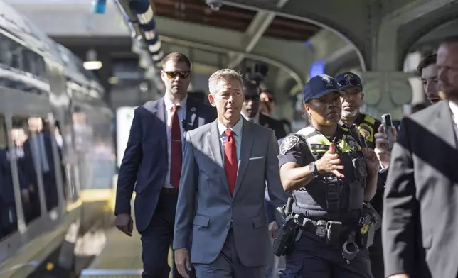 Transportation Secretary Sean Duffy is escorted to board the NextGen Acela high-speed rail service, at Union Station in Washington, Wednesday, Aug. 27, 2025. (AP Photo/J. Scott Applewhite)