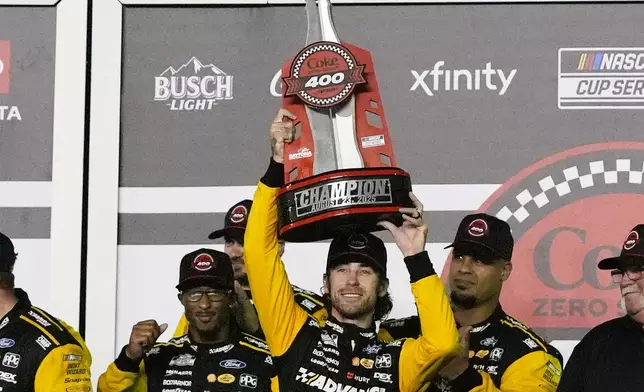 Ryan Blaney holds the championship trophy as he celebrates in Victory Lane after winning a NASCAR Cup Series auto race at Daytona International Speedway, Saturday, Aug. 23, 2025, in Daytona Beach, Fla. (AP Photo/John Raoux)