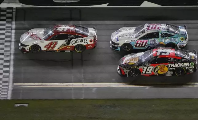 Cole Custer (41) leads Ryan Preece (60), Chase Briscoe (19) and the rest of the field at the halfway point during a NASCAR Cup Series auto race at Daytona International Speedway, Saturday, Aug. 23, 2025, in Daytona Beach, Fla. (AP Photo/John Raoux)