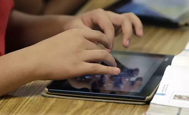 FILE - A student uses a tablet during a middle school class in Johns Creek, Ga., May 9, 2013. (AP Photo/John Bazemore, File)