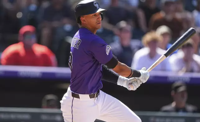 Colorado Rockies' Ryan Ritter singles to drive in two runs off Arizona Diamondbacks relief pitcher Jake Woodford in the seventh inning of a baseball game, Sunday, Aug. 17, 2025, in Denver. (AP Photo/David Zalubowski)