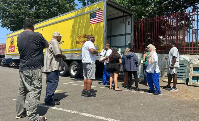 People, who were affected by a water main break that that led to reduced service to nearly 200,000 homes and businesses, pick up cases of bottled water at John F. Kennedy High School in Paterson, N.J., on Aug. 11, 2025. (AP Photo/Ted Shaffrey)
