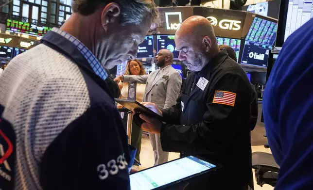 Traders Robert Charmak, left, and Fred Demarco work on the floor of the New York Stock Exchange, Friday, Aug. 15, 2025. (AP Photo/Richard Drew)