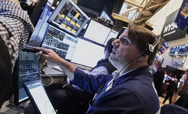 Trader Michael Milano works on the floor of the New York Stock Exchange, Friday, Aug. 15, 2025. (AP Photo/Richard Drew)