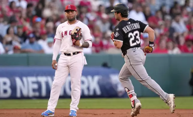 Chicago White Sox's Andrew Benintendi, right, runs by Los Angeles Angels third baseman Yoan Moncada after hitting a solo home run during the second inning of a baseball game Friday, Aug. 1, 2025, in Anaheim, Calif. (AP Photo/Mark J. Terrill)