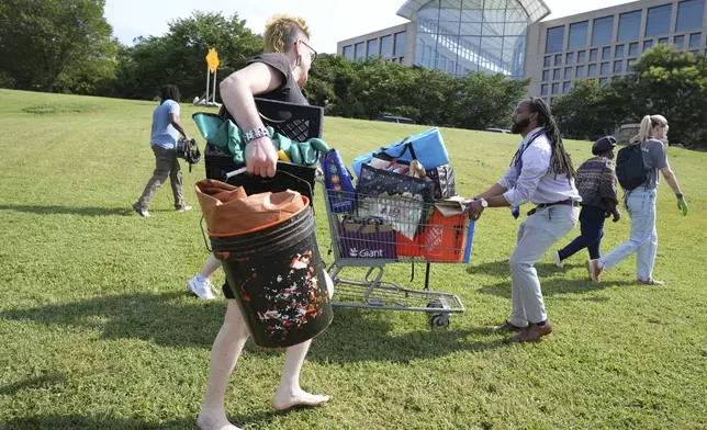 Volunteers help the homeless move their things, at a tent encampment, Thursday, Aug. 14, 2025 in Washington. (AP Photo/Jacquelyn Martin)