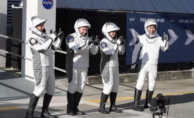 Astronauts, from left, Oleg Platonov, of Russia, Mike Fincke, Zena Cardman, and Kimiya Yui, of Japan react as they leave the Operations and Checkout Building for a trip the Kennedy Space Center's Launch Pad 39-A and a planned liftoff on a SpaceX Falcon 9 rocket Friday, Aug. 1, 2025, in Cape Canaveral , Fla. (AP Photo/John Raoux)