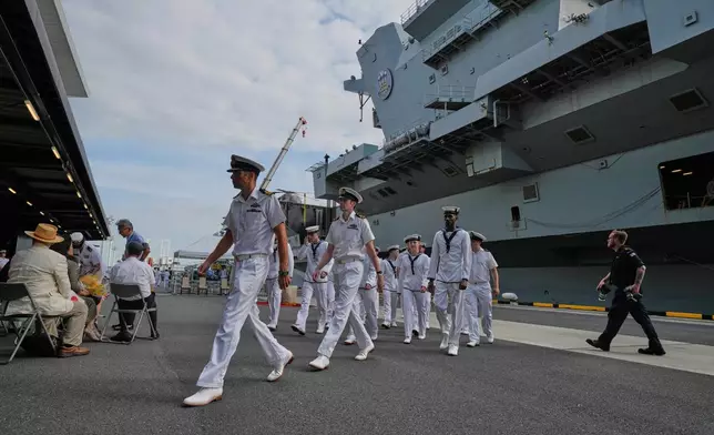 Crews walk near the Royal Navy aircraft carrier HMS Prince of Wales before its port call in Tokyo Thursday, Aug. 28, 2025. (AP Photo/Eugene Hoshiko)