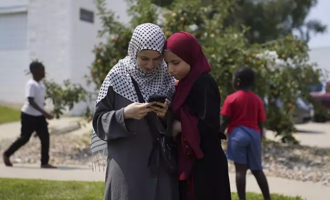 Two young girls stand together outside of the Islamic Center of Cedar Rapids after Friday prayer on Aug. 8, 2025, in Cedar Rapids, Iowa. (AP Photo/Jessie Wardarski)
