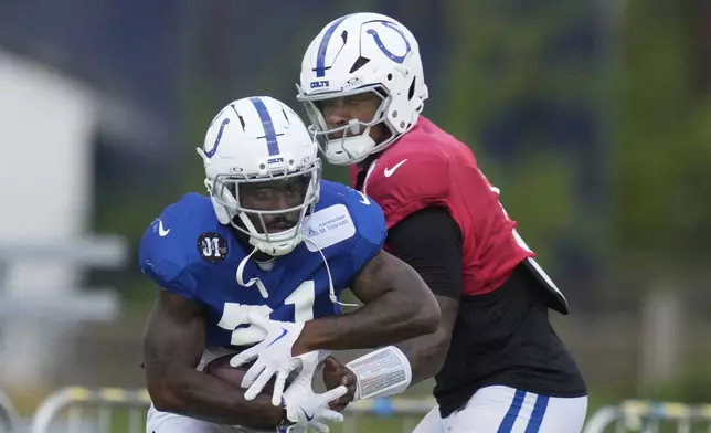 Indianapolis Colts quarterback Anthony Richardson Sr. hands off to running back Tyler Goodson during an NFL football joint training camp with the Green Bay Packers, Thursday, Aug. 14, 2025, in Westfield, Westfield, Ind. (AP Photo/Darron Cummings)