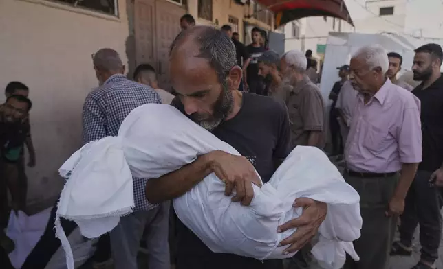 Ahmed Al-Hajj carries the body of his daughter, Dana Al-Hajj, 13, who was killed in an Israeli airstrike in the Gaza Strip, at Al-Aqsa Hospital in Deir al-Balah, Tuesday, Aug. 19, 2025. (AP Photo/Abdel Kareem Hana)
