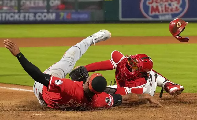Cincinnati Reds' Will Benson, left, is tagged out by Los Angeles Angels catcher Travis d'Arnaud while trying to score on a double by Gavin Lux during the ninth inning of a baseball game Tuesday, Aug. 19, 2025, in Anaheim, Calif. (AP Photo/Mark J. Terrill)