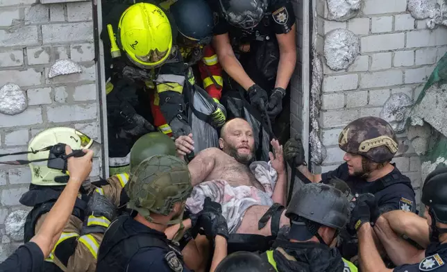 Rescuers evacuate an injured civilian after a residential building was hit following Russia's missile attack in Kharkiv, Ukraine, Monday, Aug. 18, 2025. (AP Photo/Andrii Marienko)