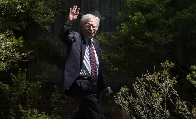 Former national security adviser John Bolton waves as he arrives at his house Friday, Aug. 22, 2025, in Bethesda, Md. (AP Photo/Manuel Balce Ceneta)