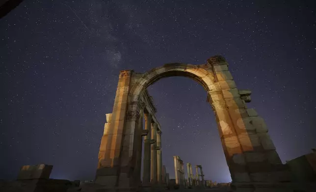 The entrance to the Roman Theater's precinct, part of the ruins of the ancient city of Palmyra, is seen under a star-studded sky in Syria, late Wednesday, Aug. 27, 2025. (AP Photo/Ghaith Alsayed)