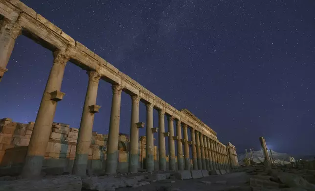 The colonnaded Long Street in the ruins of the ancient city of Palmyra is seen under a star-filled sky in Syria, early Wednesday, Aug. 27, 2025. (AP Photo/Ghaith Alsayed)