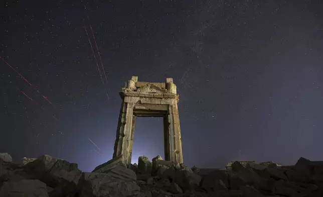 The façade of the Temple of Bel's precinct, in the ruins of the ancient city of Palmyra, is seen under a star-studded sky in Syria, early Wednesday, Aug. 27, 2025. (AP Photo/Ghaith Alsayed)