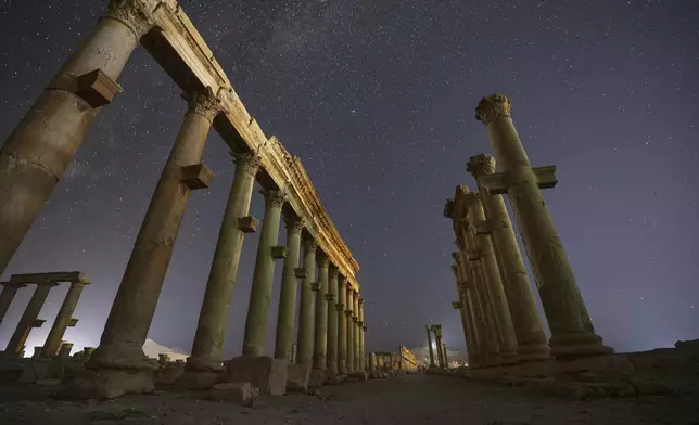 The colonnaded Long Street in the ruins of the ancient city of Palmyra is seen under a star-filled sky in Syria, early Thursday, Aug. 28, 2025. (AP Photo/Ghaith Alsayed)