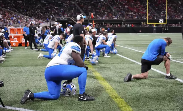 Detroit Lions players take a knee after safety Morice Norris was injured against the Atlanta Falcons during the second half of an NFL preseason football game Friday, Aug. 8, 2025, in Atlanta. (AP Photo/Brynn Anderson)