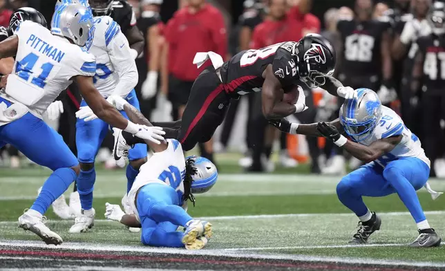Detroit Lions safety Morice Norris (26) is hit in the helmet by Atlanta Falcons running back Nathan Carter (38) during the second half of an NFL preseason football game Friday, Aug. 8, 2025, in Atlanta. (AP Photo/Brynn Anderson)