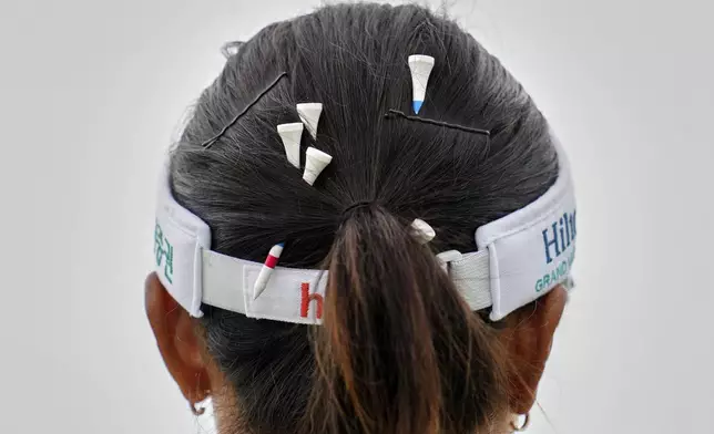 Tees are pinned in the hair of Lydia Ko of New Zealand during the third round of the Women's British Open golf championship, at Royal Porthcawl Golf Club in Porthcawl, Wales, Saturday, Aug. 2, 2025. (AP Photo/Kin Cheung)