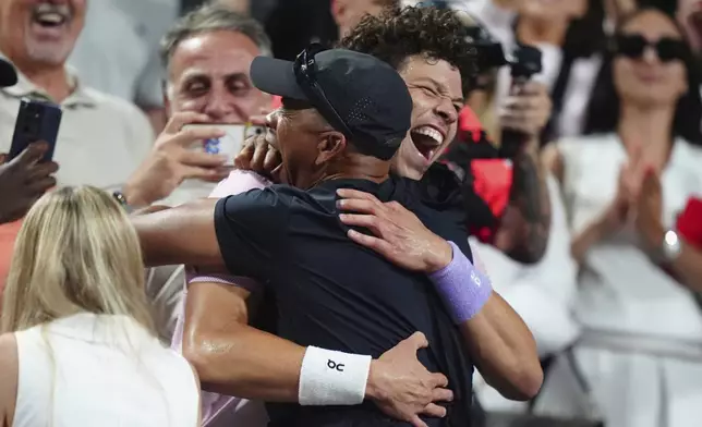 Ben Shelton, center right, of the United States, celebrates after his win over Karen Khachanov, of Russia, with his father Bryan Shelton, center left, after the final match at the National Bank Open men's tennis tournament in Toronto, Thursday, Aug. 7, 2025. (Frank Gunn/The Canadian Press via AP)