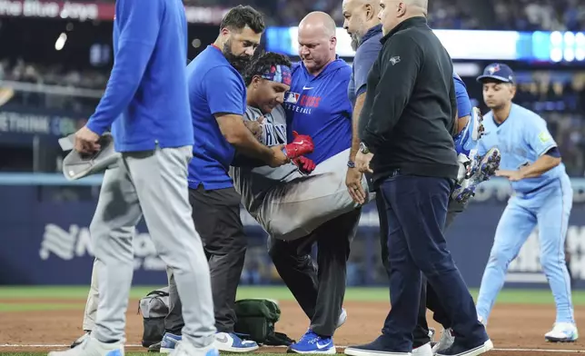 Chicago Cubs catcher Miguel Amaya (9) is tended to by medical staff and leaves the game during eighth inning MLB baseball action against the Toronto Blue Jays in Toronto on Wednesday, August 13, 2025. (Nathan Denette/The Canadian Press via AP)