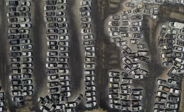 Burned cars are seen at an impound lot in Kato Achaia, during a wildfire near Patras city, western Greece, Wednesday, Aug. 13, 2025. (AP Photo/Thanassis Stavrakis)