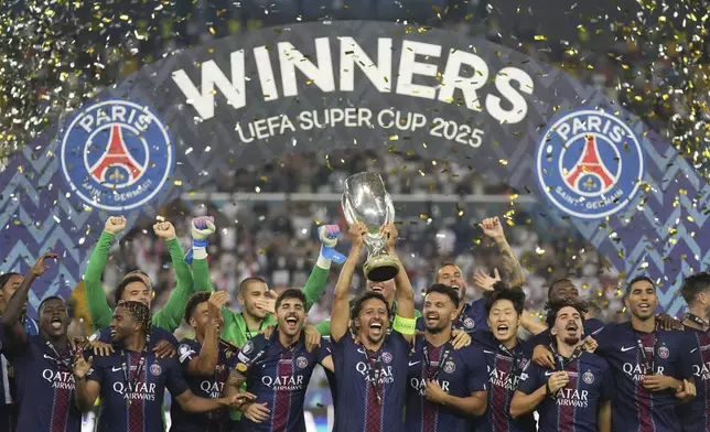 PSG's Marquinhos lifts the trophy with teammates after the UEFA Super Cup soccer match between Paris Saint-Germain and Tottenham Hotspur in Udine, Italy, Wednesday, Aug. 13, 2025. (AP Photo/Antonio Calanni)