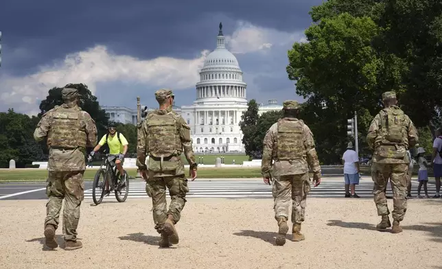 District of Columbia National Guard soldiers patrol on the National Mall, Thursday, August 14, 2025, in Washington. The U.S. Capitol is seen in the distance. (AP Photo/Jacquelyn Martin)