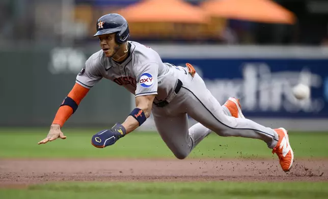Houston Astros' Jeremy Pena dives as he steals third base during the first inning of a baseball game against the Baltimore Orioles, Sunday, Aug. 24, 2025, in Baltimore. (AP Photo/Nick Wass)