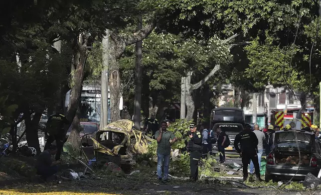 Security forces inspect the site of a bomb explosion outside an Air Force base in Cali, Colombia, Thursday, Aug. 21, 2025. (AP Photo/Santiago Saldarriaga)