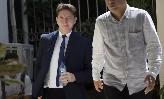 U.S. citizen William Wallace Molyneaux V of Brooksville, Fla., left, who is charged with importing drugs to Indonesia, walks with his lawyer upon arrival for a hearing at the district court in Denpasar, Bali, Indonesia on Tuesday, Aug. 5, 2025. (AP Photo/Firdia Lisnawati)