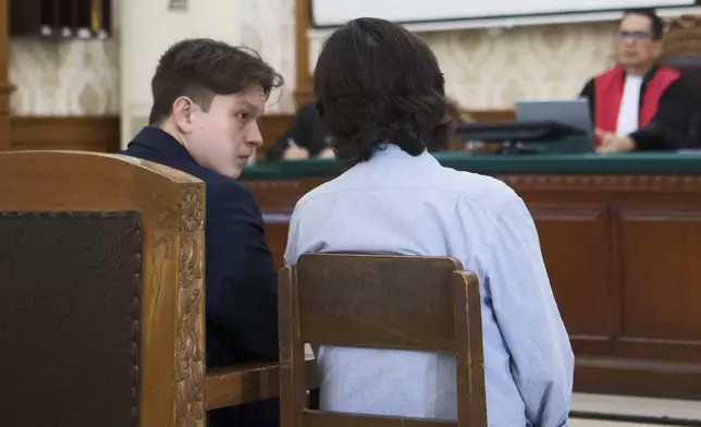 U.S. citizen William Wallace Molyneaux V of Brooksville, Fla., who is charged with importing drugs to Indonesia, talks to an interpreter as he sits on the defendant's chair during a hearing at the district court in Denpasar, Bali, Indonesia on Tuesday, Aug. 5, 2025. (AP Photo/Firdia Lisnawati)