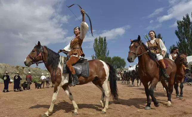 Kyrgyz women archers ride horses prior to competition during the Traditional Eagle Hunting Salbuurun Festival on the southern shore of Issyk-Kul lake, 213 km (132 miles) southeast of Bishkek, Kyrgyzstan, on Saturday, Aug. 2, 2025. (AP Photo/Vladimir Voronin)