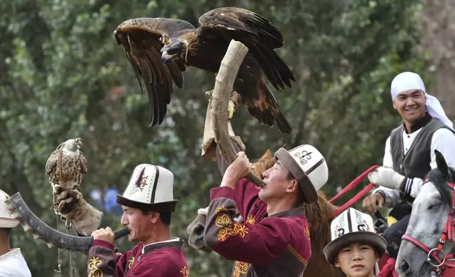 Kyrgyz hunters blow hunting horns opening the Traditional Eagle Hunting Salbuurun Festival on the southern shore of Issyk-Kul lake, 213 km (132 miles) southeast of Bishkek, Kyrgyzstan, on Saturday, Aug. 2, 2025. (AP Photo/Vladimir Voronin)