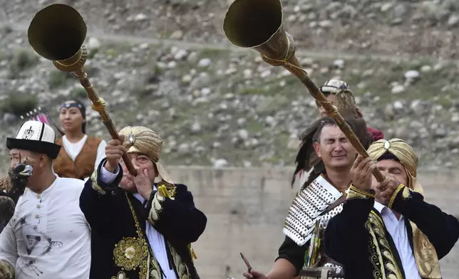 Kyrgyz musicians play national instruments Karnay starting the Traditional Eagle Hunting Salbuurun Festival on the southern shore of Issyk-Kul lake, 213 km (132 miles) southeast of Bishkek, Kyrgyzstan, on Saturday, Aug. 2, 2025. (AP Photo/Vladimir Voronin)