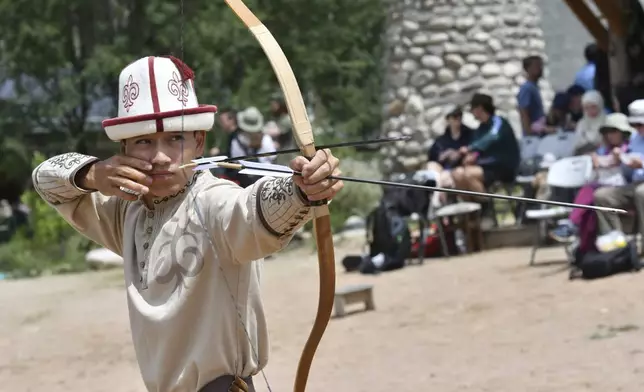A Kyrgyz boy competes in archery during the Traditional Eagle Hunting Salbuurun Festival on the southern shore of Issyk-Kul lake, 213 km (132 miles) southeast of Bishkek, Kyrgyzstan, on Saturday, Aug. 2, 2025. (AP Photo/Vladimir Voronin)