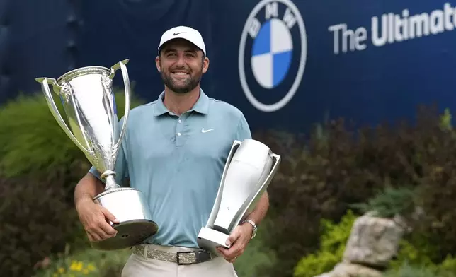 Scottie Scheffler poses with the trophies after winning the BMW Championship golf tournament Sunday, Aug. 17, 2025, in Owings Mills, Md. (AP Photo/Stephanie Scarbrough)