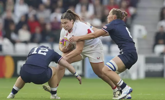 Maud Muir of England, center is tackled by Alev Kelter of the United States, left and Kate Zackary of the United States during the group A match at the 2025 Women's Rugby World Cup between England and the United States in Sunderland, England, Friday, Aug. 22, 2025. (AP Photo/Scott Heppell)