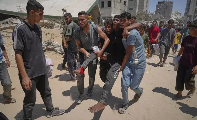 Palestinians carry a wounded man who was injured while rushing to collect humanitarian aid airdropped by parachute into Gaza City, in the northern Gaza Strip, Thursday, Aug. 7, 2025. (AP Photo/Jehad Alshrafi)