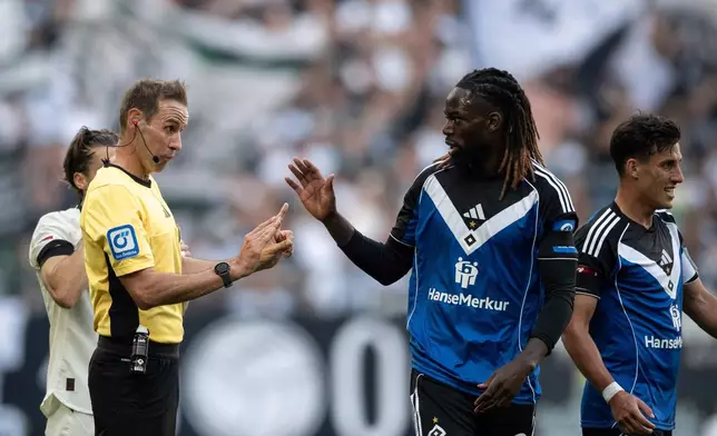 Referee Sascha Stegemann talks to Hamburg's Jordan Torunarigha during the German Bundesliga soccer match between Borussia Mönchengladbach and Hamburger SV at Borussia-Park in Mönchengladbach, Germany, Sunday Aug. 24, 2025. (Fabian Strauch/dpa via AP)